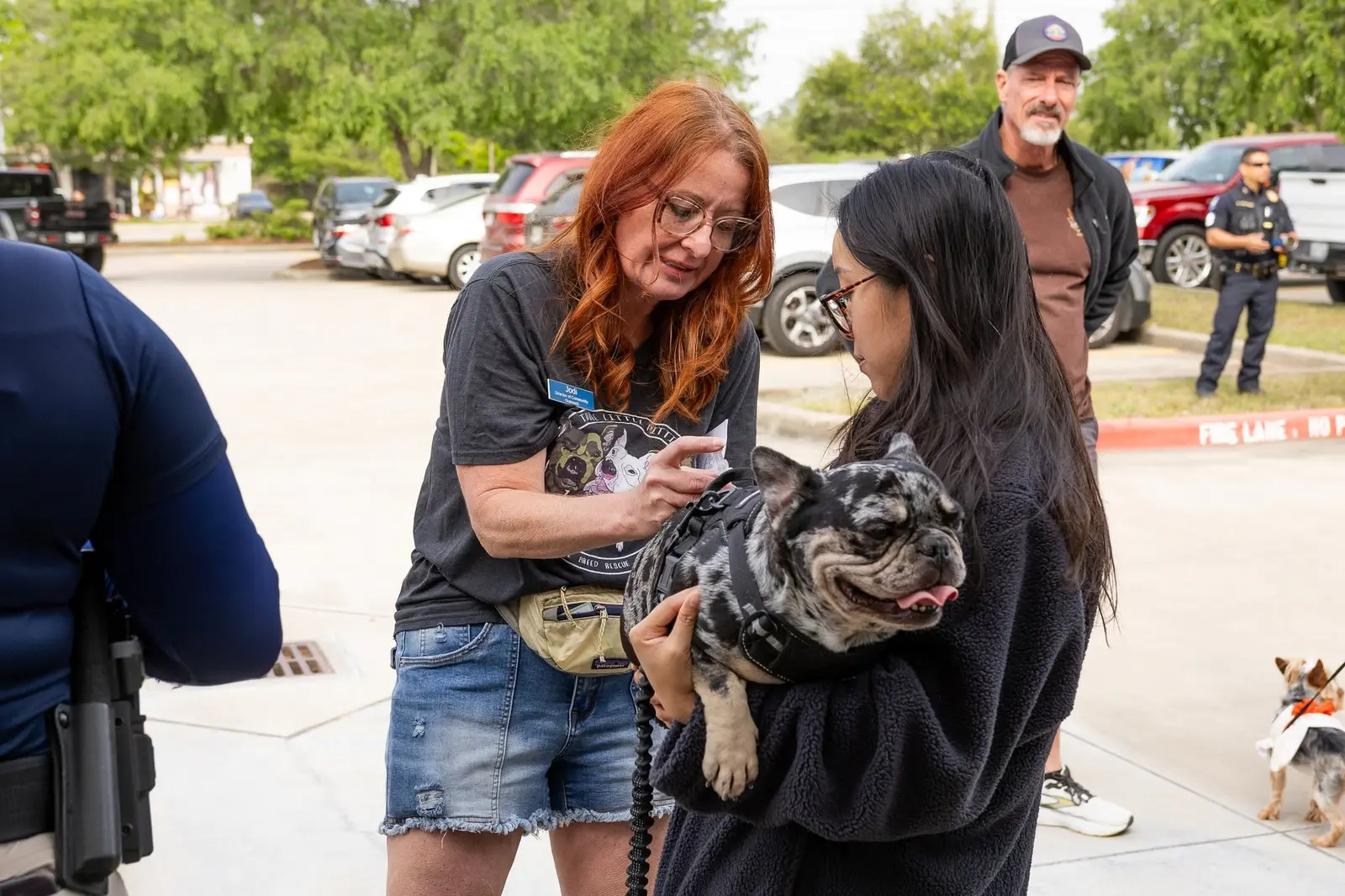 Jodi helping a community member and her French bulldog